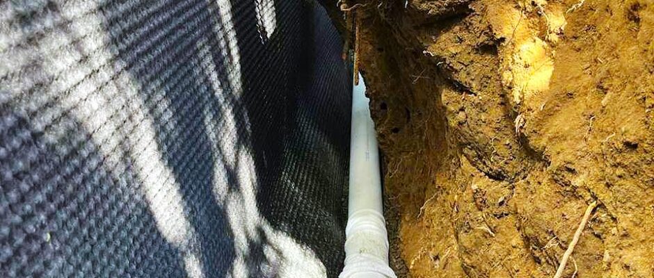 French drain trench with perforated pipe and filter fabric at a Seattle-area foundation