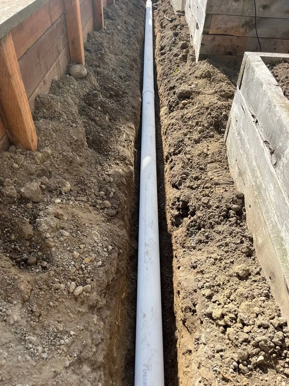 long-exterior-pvc-drainage-pipe-in-trench-bothell-wa Foundation drainage and waterproofing work by Basement Expert
