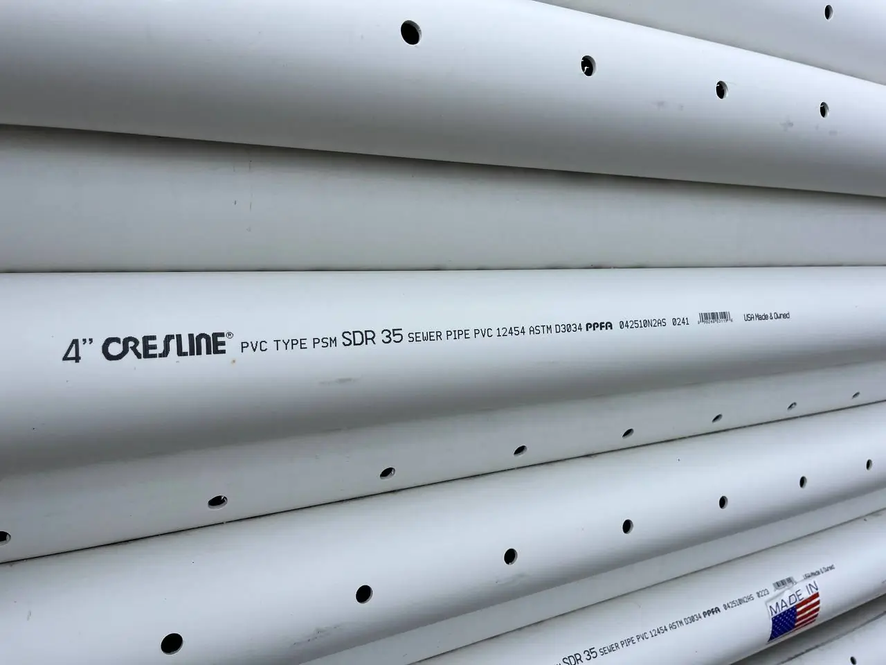 perforated-pvc-drain-pipe-stack-foundation-waterproofing-bothell-wa Excavation trench for exterior collector installation